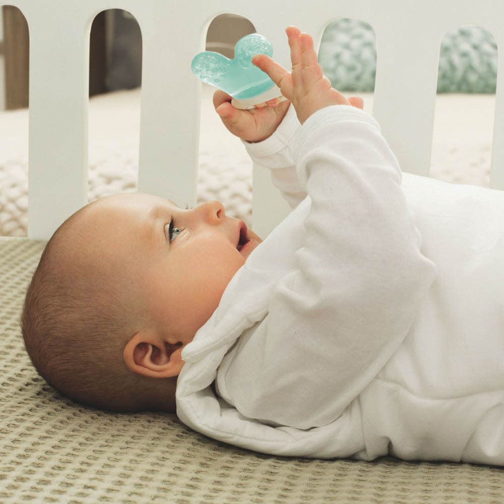 Un bambino tiene un massaggiagengive blu a forma di cuore.