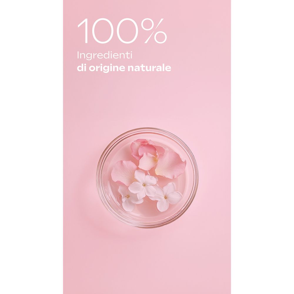 Sfondo rosa con ciotola piena di fiori e petali. Testo: "100% Ingredienti di origine naturale".