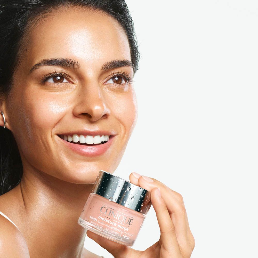 Donna che tiene in mano il Clinique Moisture Surge 100H Auto-Replenishing Hydrator.