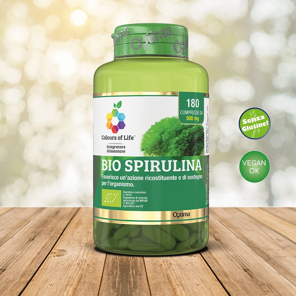Barattolo verde con compresse Bio Spirulina su sfondo di legno. Con etichette Senza Glutine e Vegan.