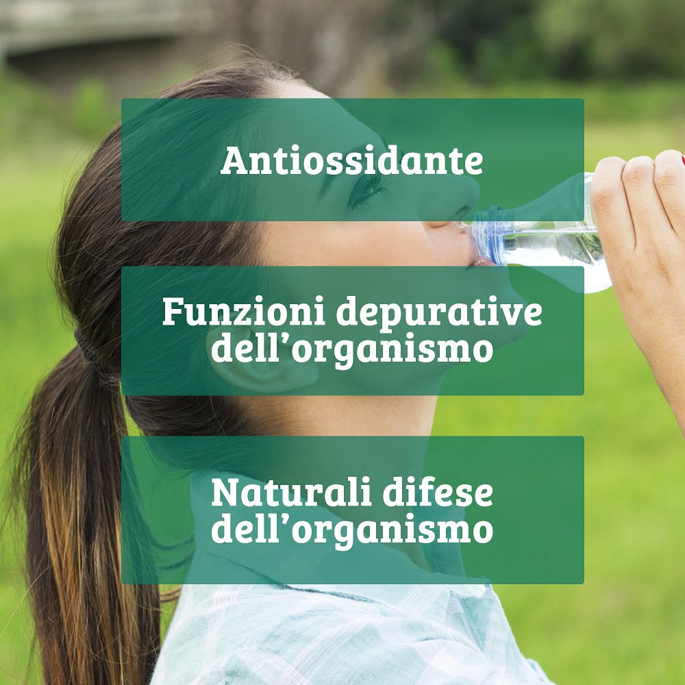 Donna beve acqua, evidenziando i benefici della Bio Chlorella.