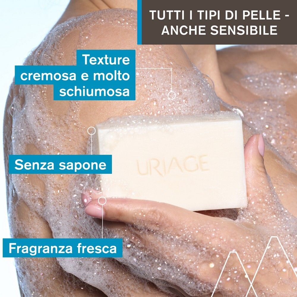 Persona che si lava con il sapone. Sapone con logo URIAGE. Testo: texture cremosa, senza sapone, profumo fresco.