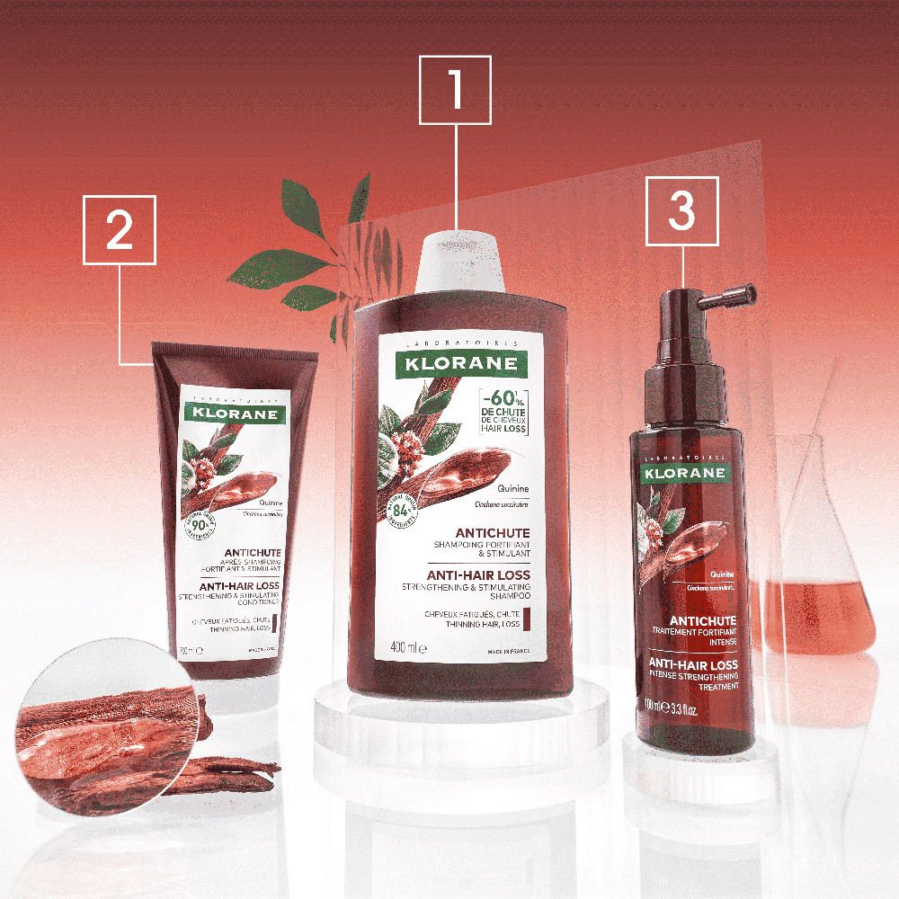 Tre prodotti su un piedistallo. Bottiglia, tubo e flacone spray. Testo: Klorane, Antichute, Anti-Hair Loss.