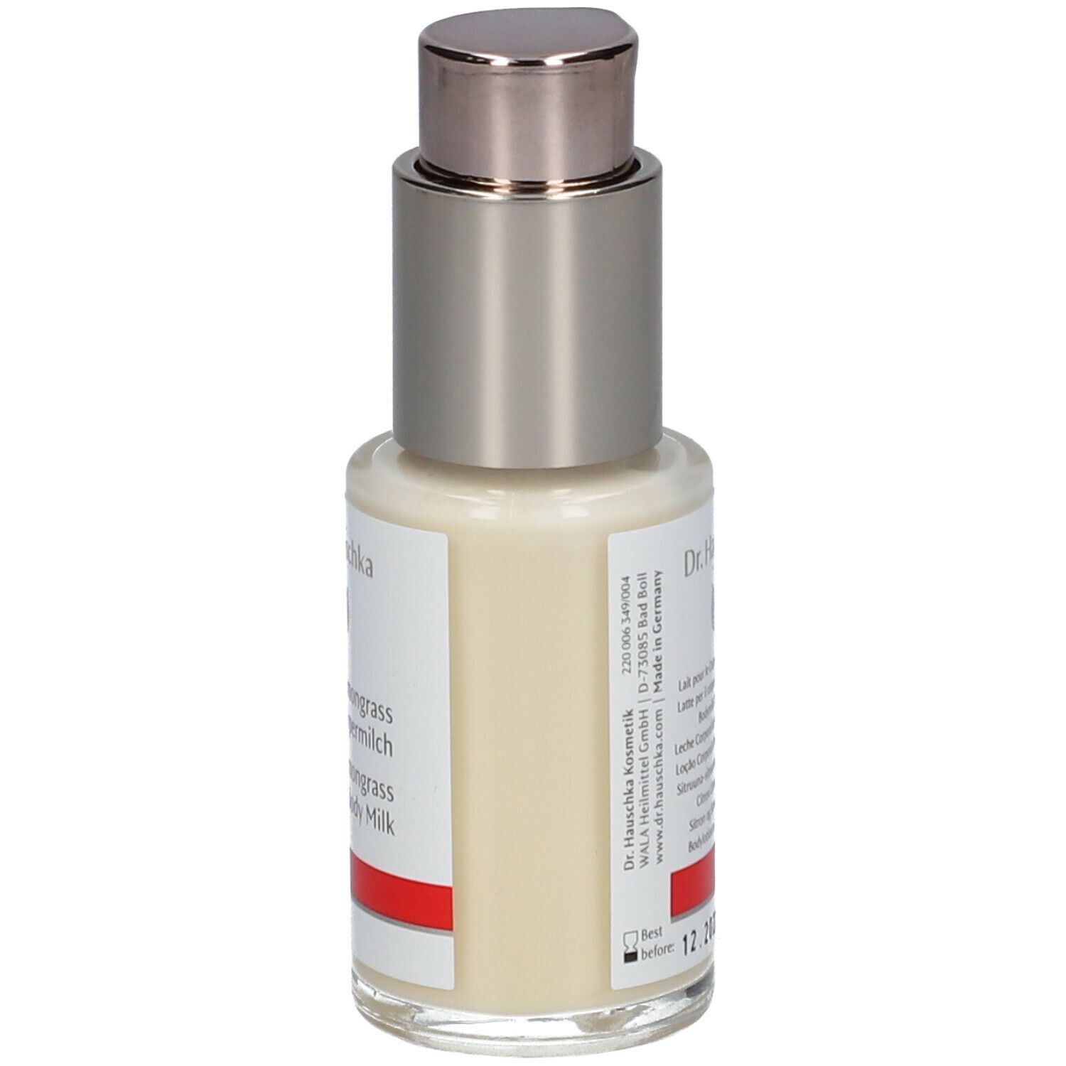 Flacone con dispenser di crema con etichetta. Scritta: Dr. Hauschka, Latte corpo Limone Lemongrass. Striscia rossa.