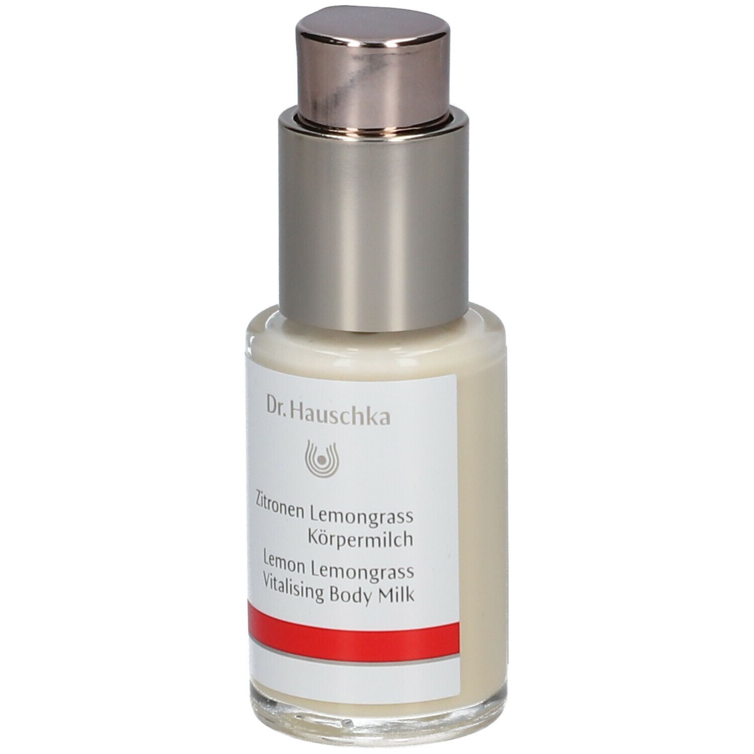 Flacone con dispenser di crema con etichetta. Scritta: Dr. Hauschka, Latte corpo Limone Lemongrass. Striscia rossa.