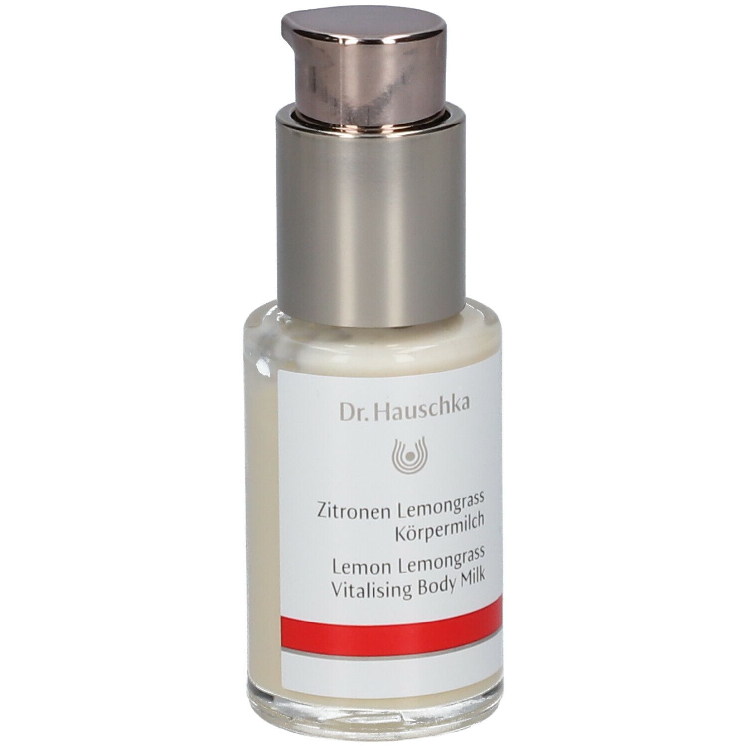 Flacone con dispenser di crema con etichetta. Scritta: Dr. Hauschka, Latte corpo Limone Lemongrass. Striscia rossa.