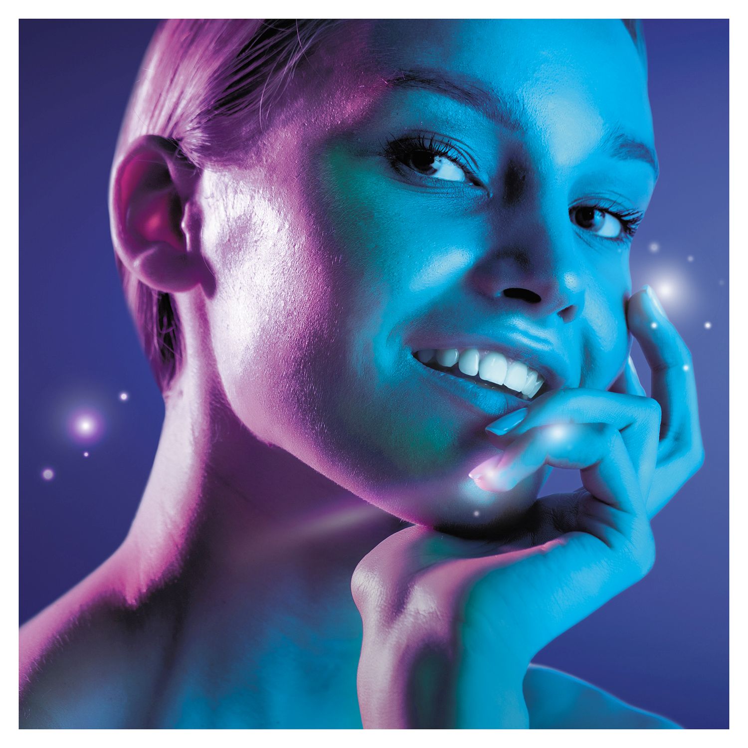 Ritratto di una donna con un sorriso radioso. Illuminazione blu e rosa.