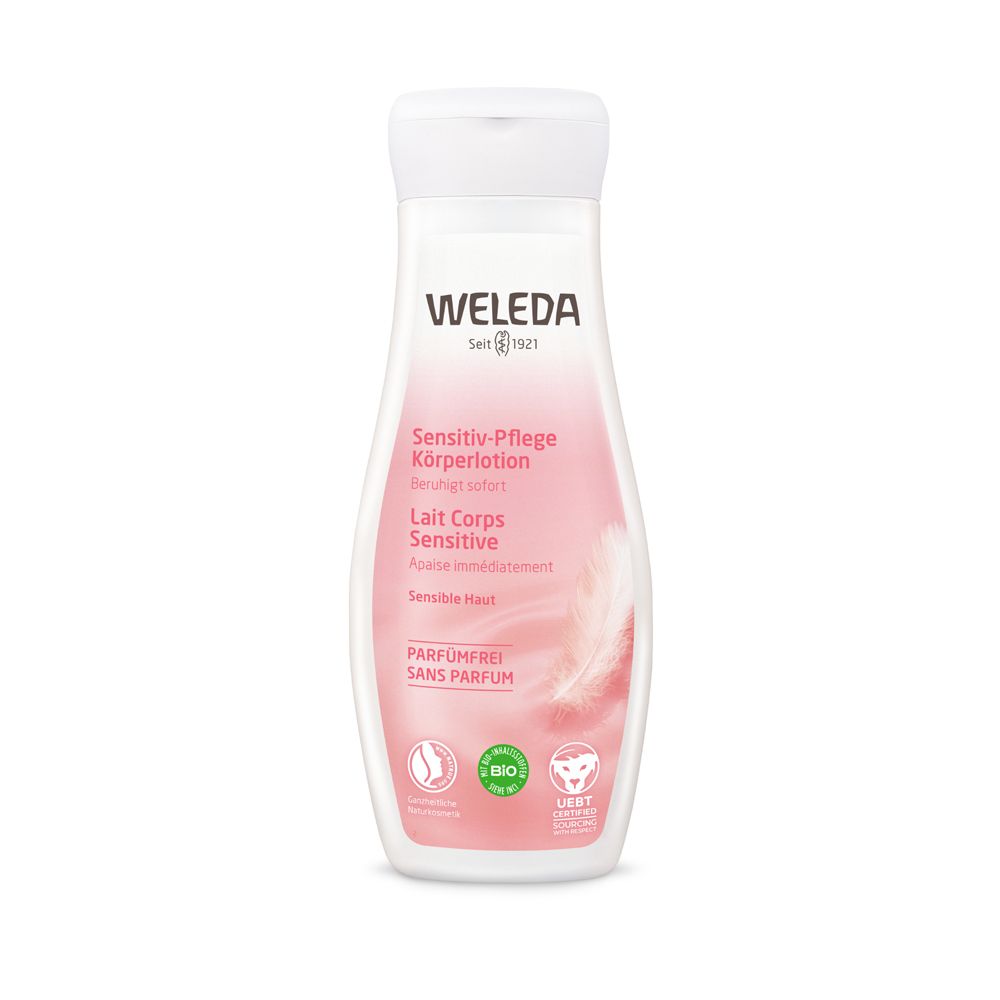 Flacone con tappo bianco. Scritte: WELEDA, Lait Corps Sensitive, senza profumo. Logo bio visibile.