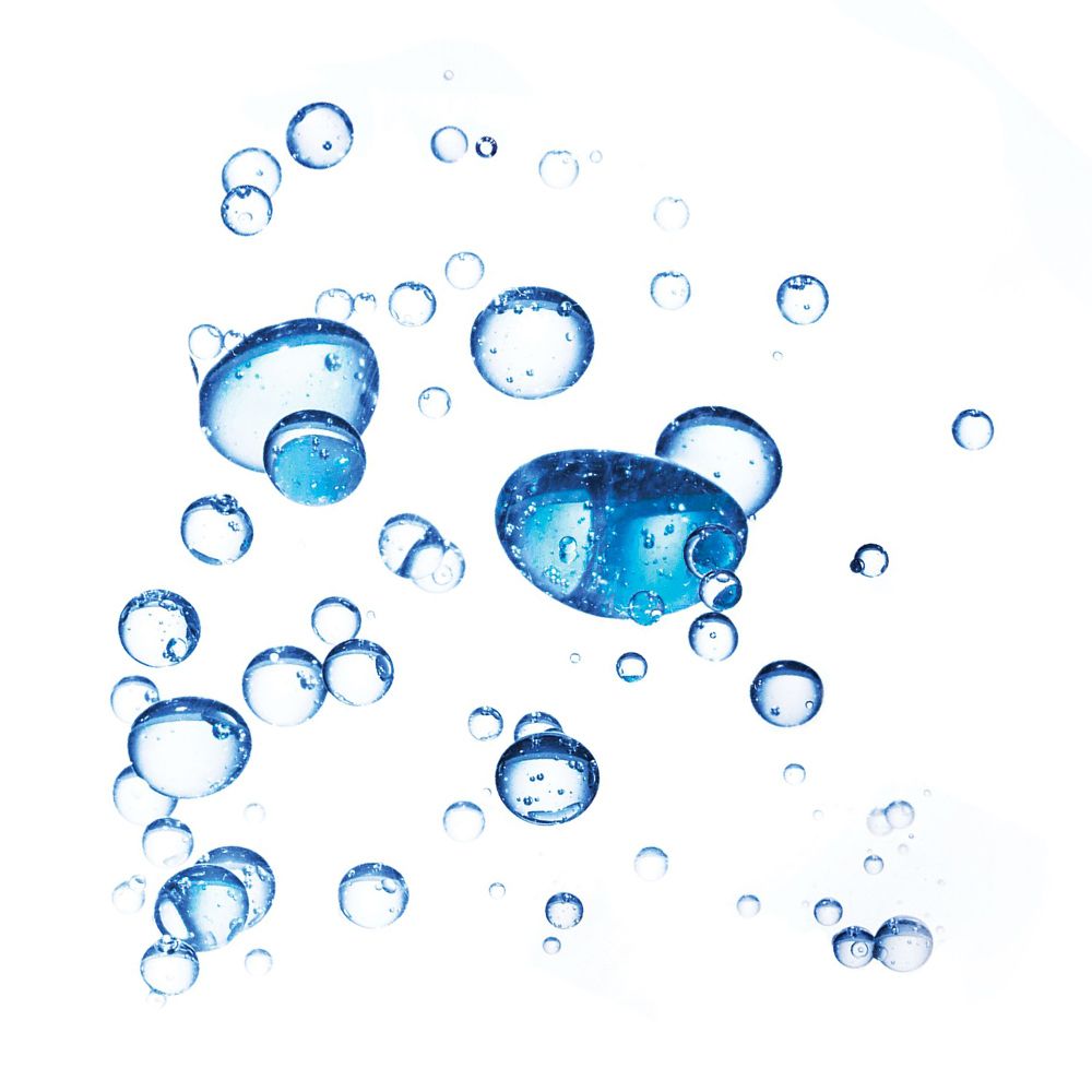 Primo piano di bolle blu su sfondo bianco. Alcune bolle sono più grandi.