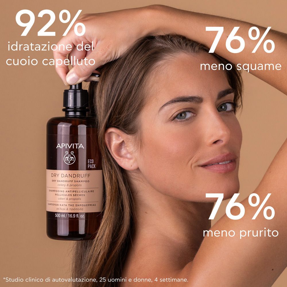 Donna tiene flacone shampoo. Scritta: APIVITA, Dry Dandruff Shampoo. 92% idratazione, 76% meno squame, prurito.