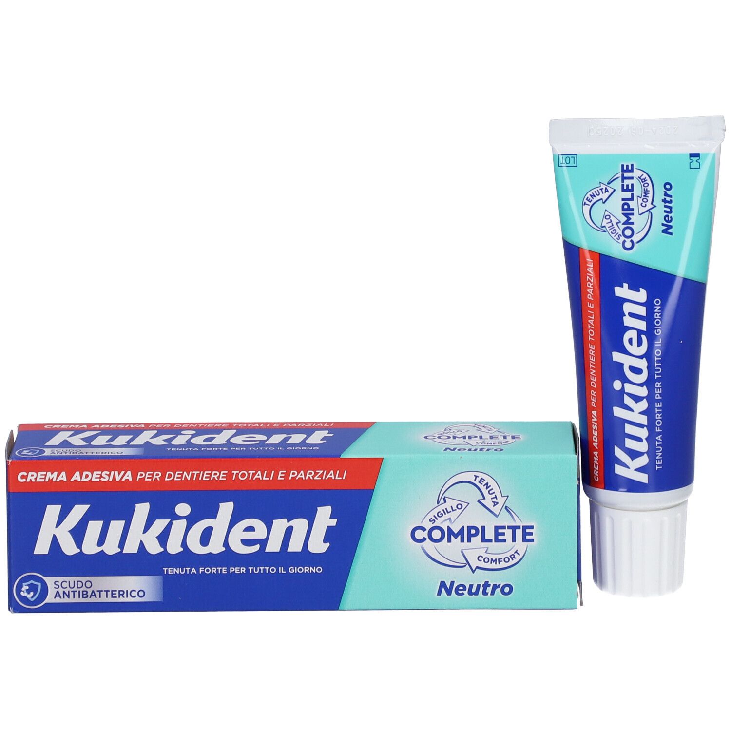 Tubo e scatola di crema adesiva Kukident Complete Neutro. Scritta blu, sfondo rosso e verde. Antibatterico.