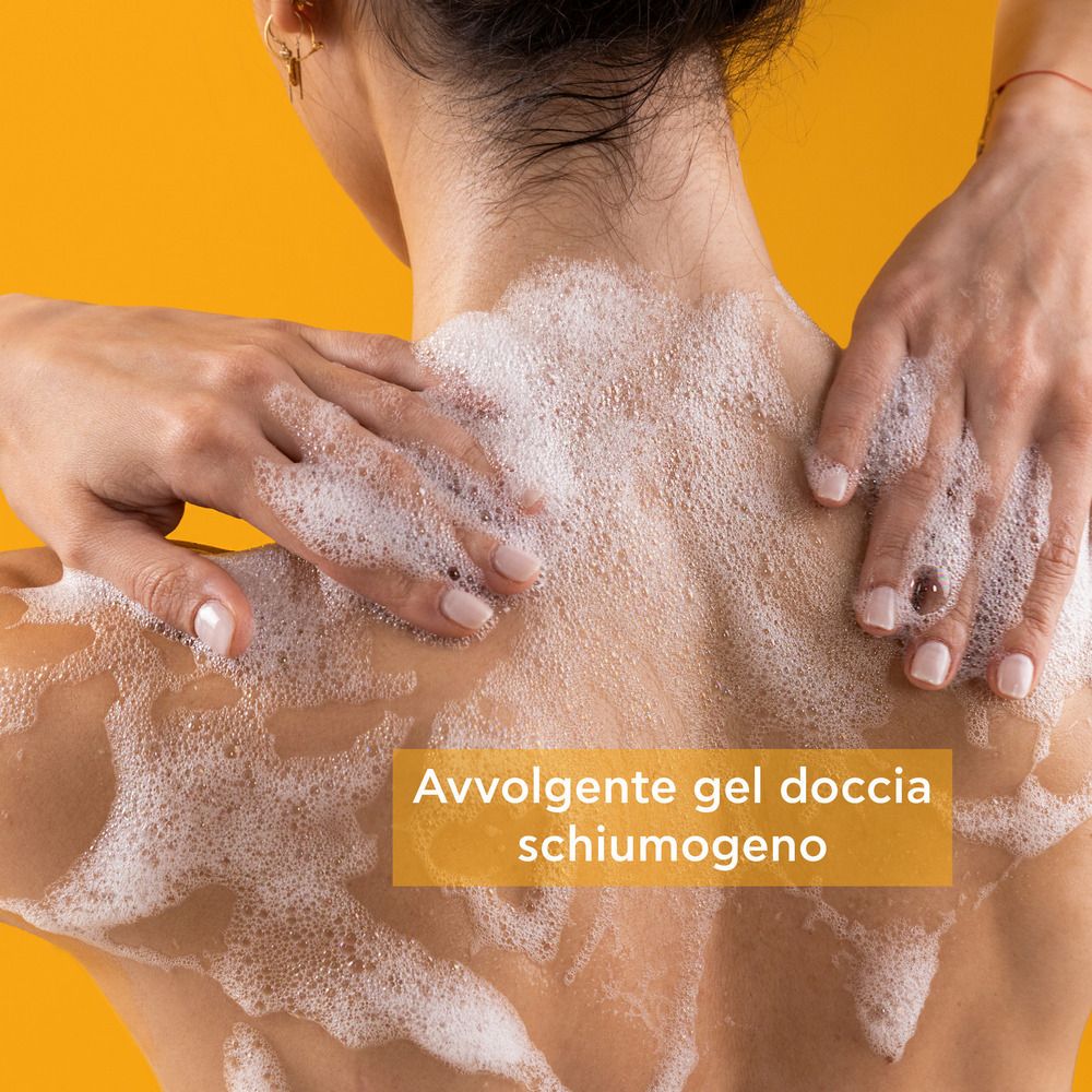 Schiena di una persona ricoperta di schiuma. Sfondo giallo. Testo: Gel doccia avvolgente e schiumogeno.