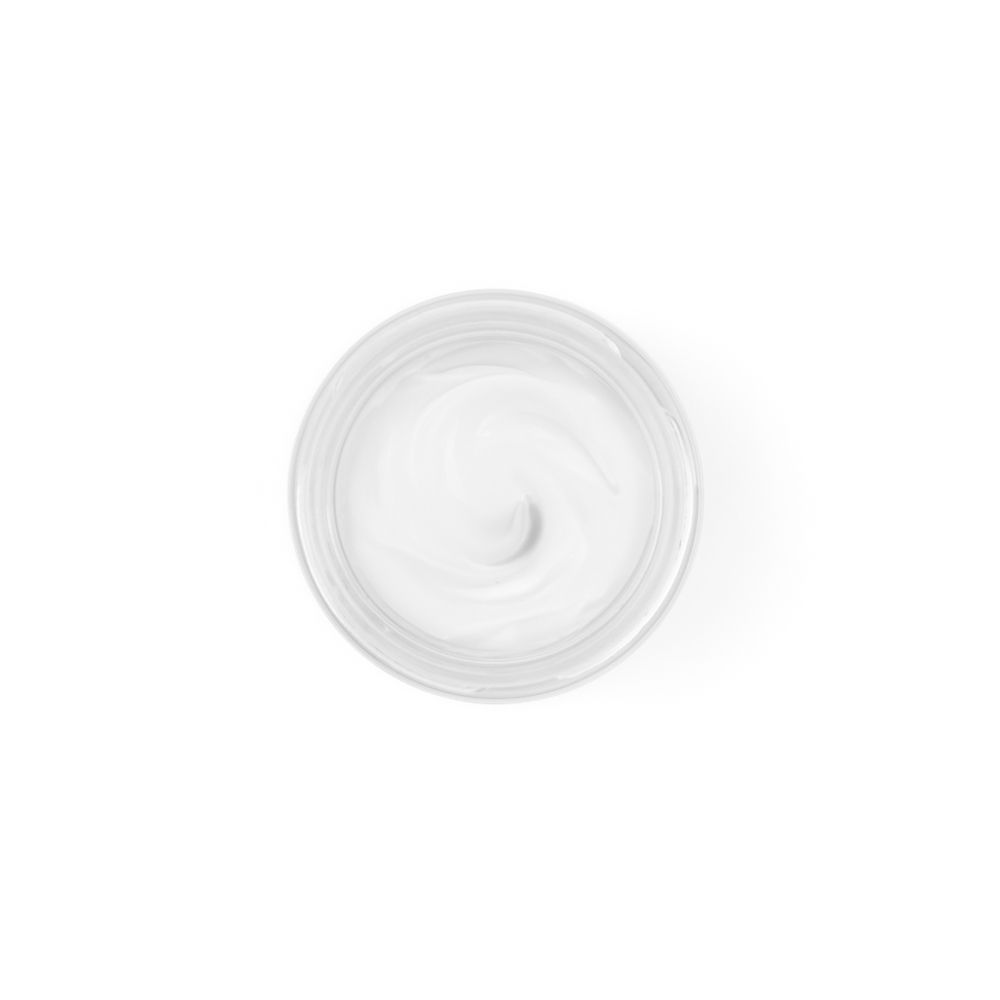 Vista dall'alto di una crema. Crema bianca in un vasetto trasparente. Consistenza cremosa.