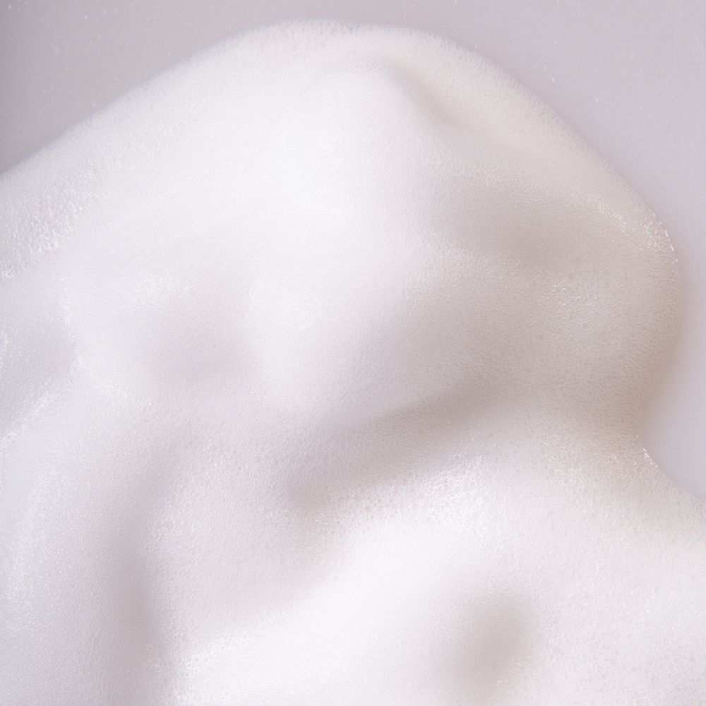 Primo piano di schiuma bianca. Texture con bolle piccole e grandi. Superficie chiara e morbida.