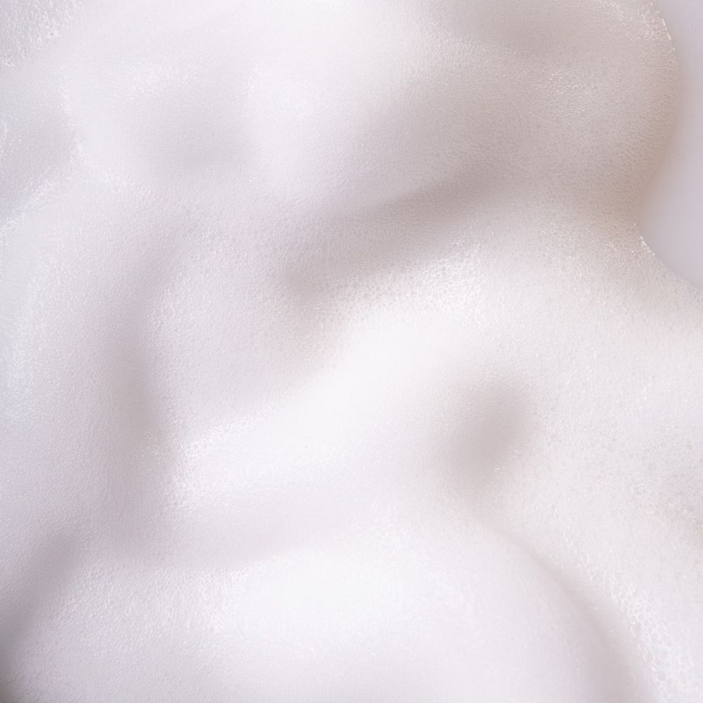 Primo piano di schiuma bianca. Struttura con piccole bolle.