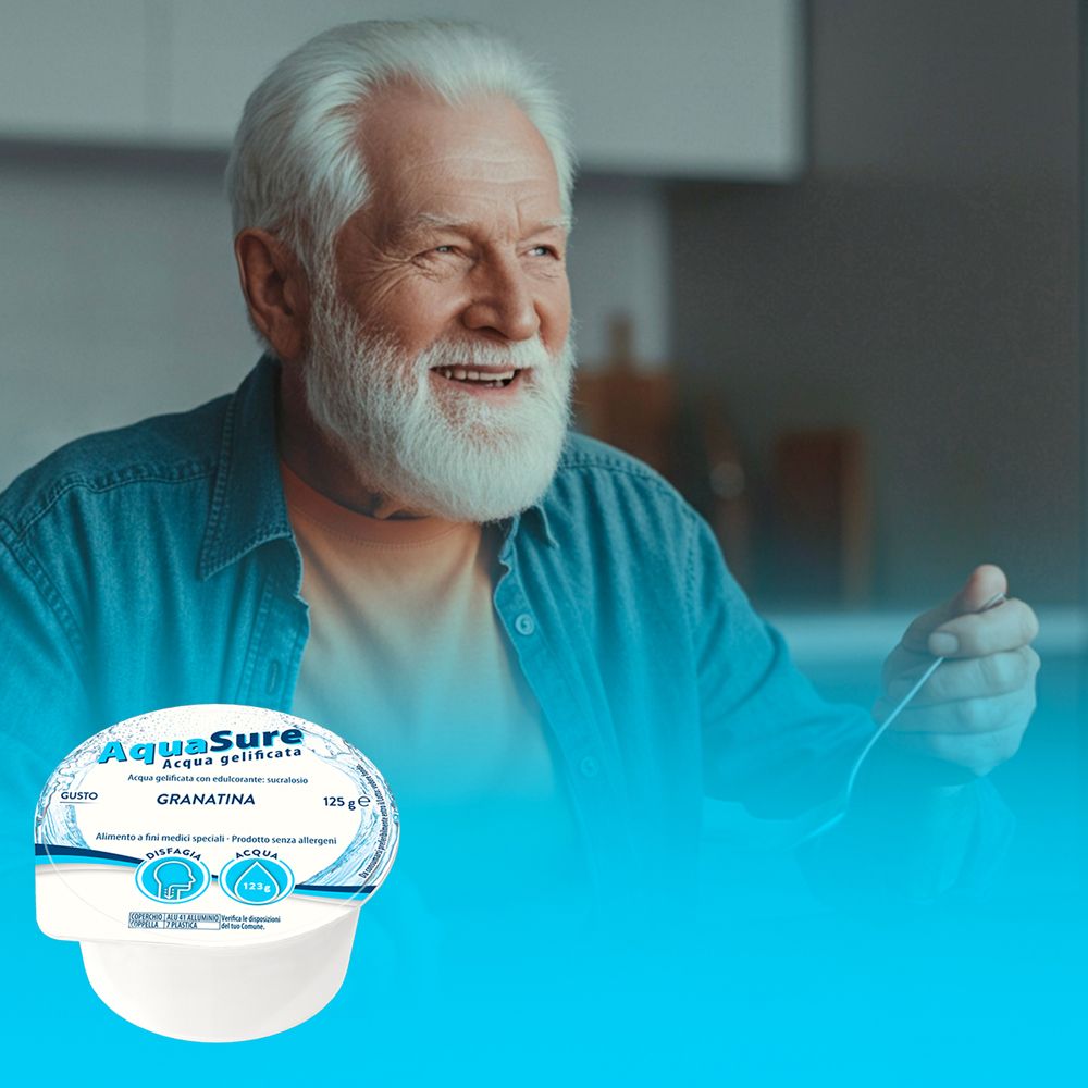 Uomo anziano mangia AquaSure Acqua gelificata. Vaschetta gusto Granatina.