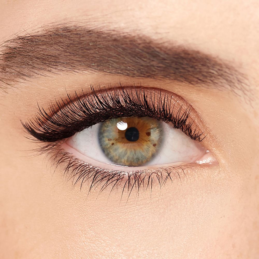 Occhio con ciglia truccate. Mascara nero, iride verde, pelle chiara.