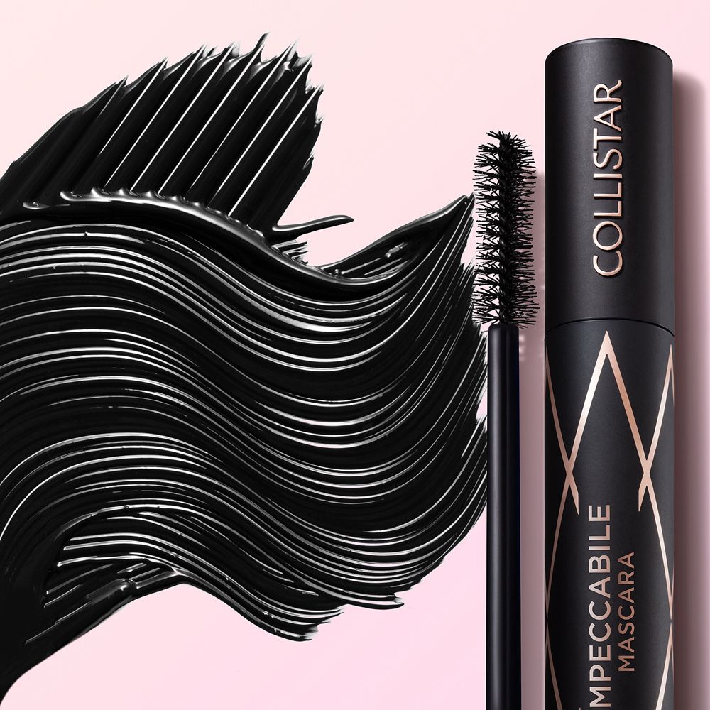 Texture di mascara nero. Spazzola e prodotto affiancati. Sfondo rosa.