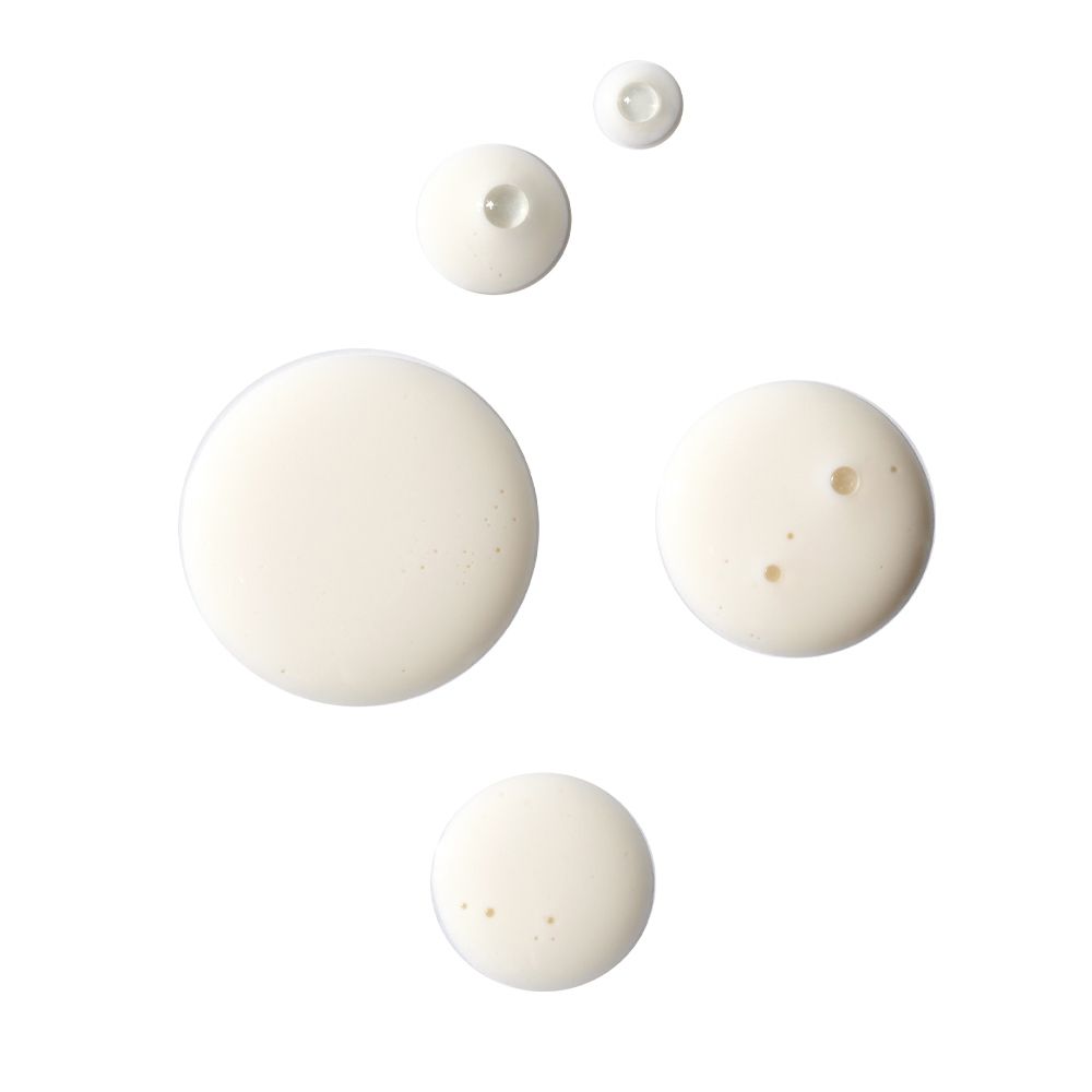 Diverse gocce di liquido bianco su sfondo bianco. Forme rotonde, diverse dimensioni.