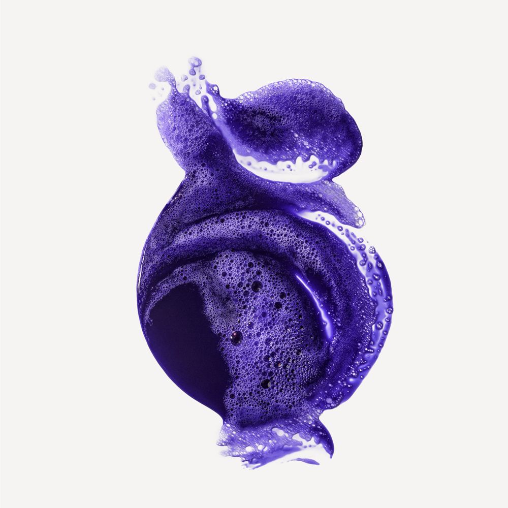 Rappresentazione artistica di schiuma di shampoo viola. Schiuma con bolle, a forma di onda. Su sfondo bianco.