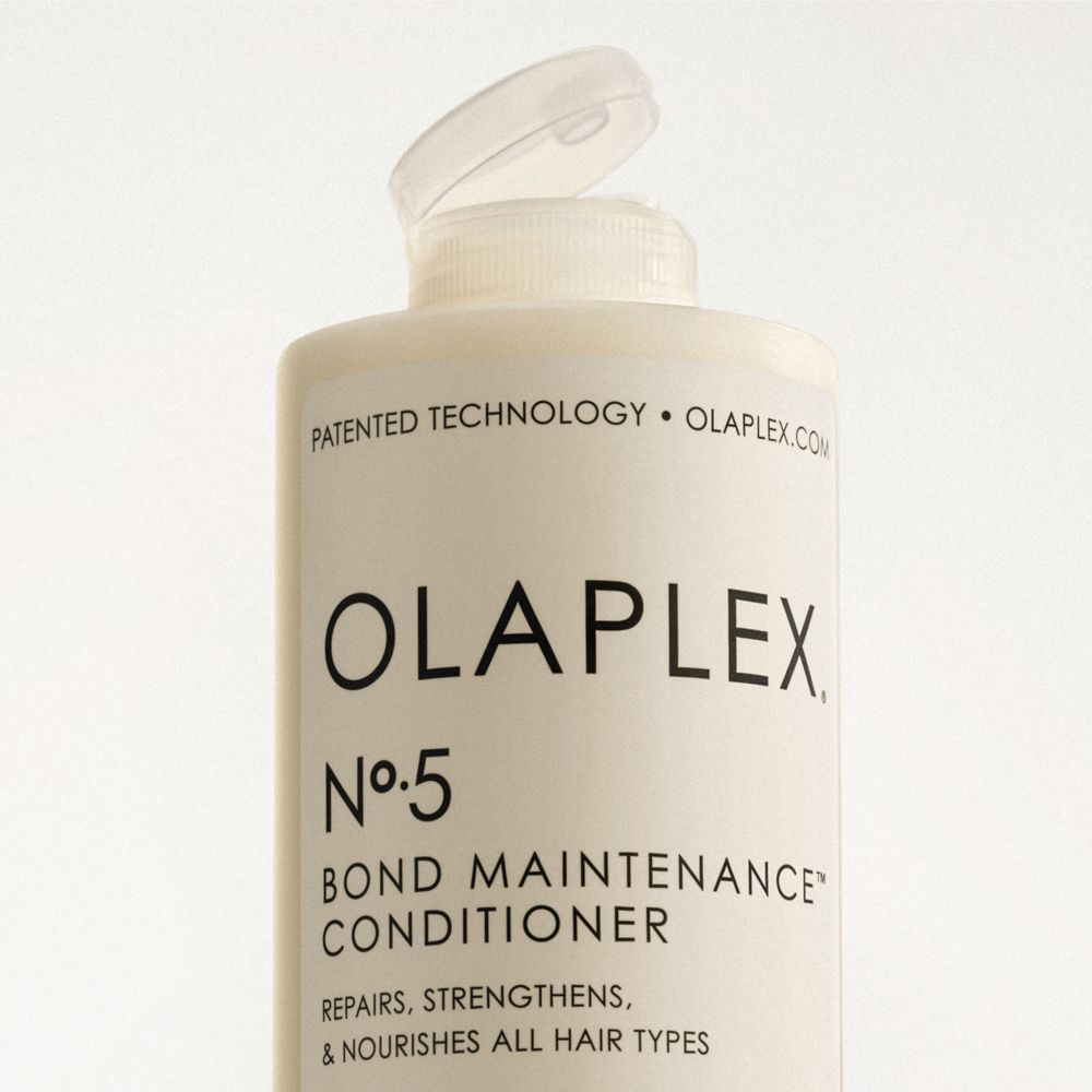 Primo piano del tappo aperto di un flacone di balsamo OLAPLEX No. 5.