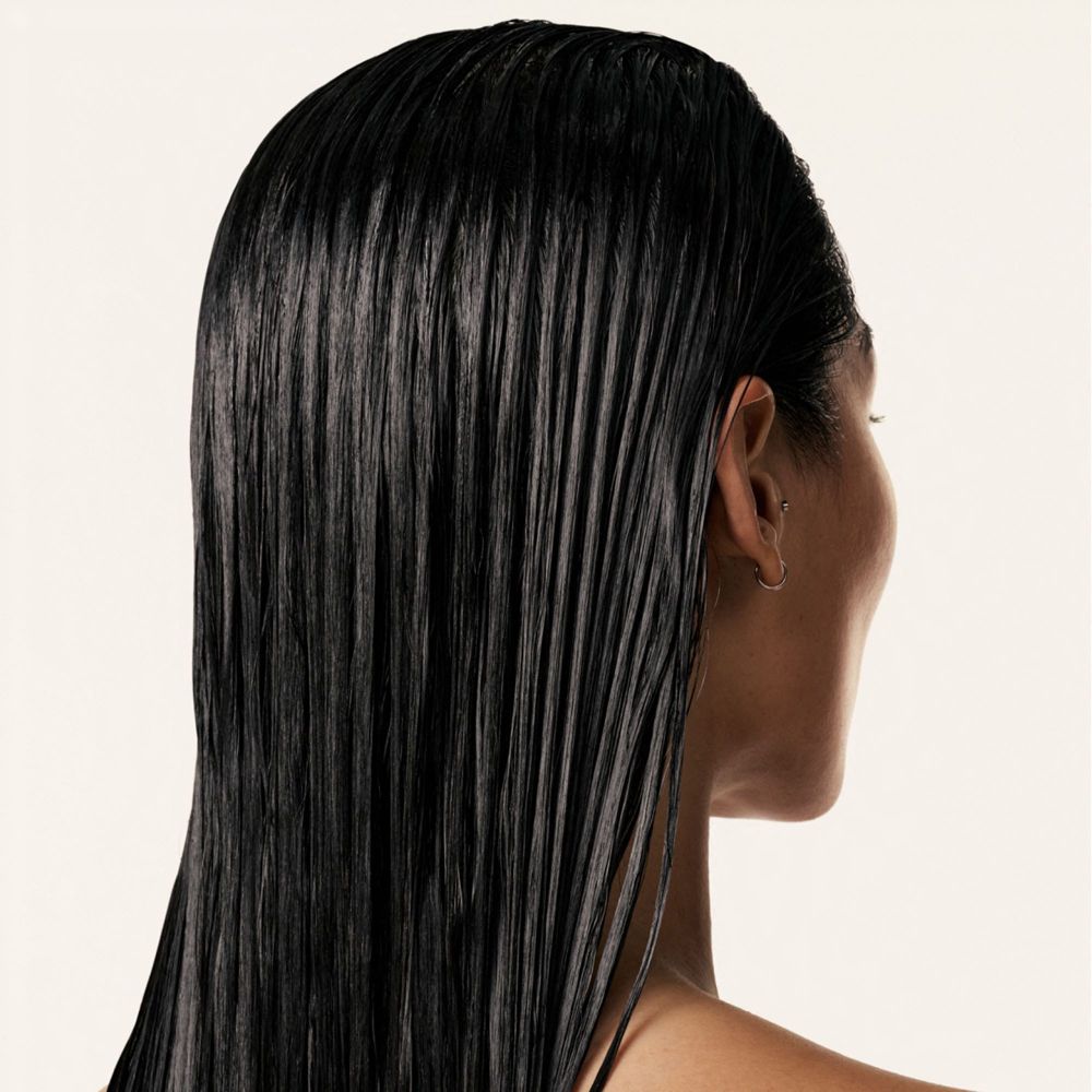 Vista posteriore di una persona con capelli neri lucenti. Capelli bagnati e lisci.