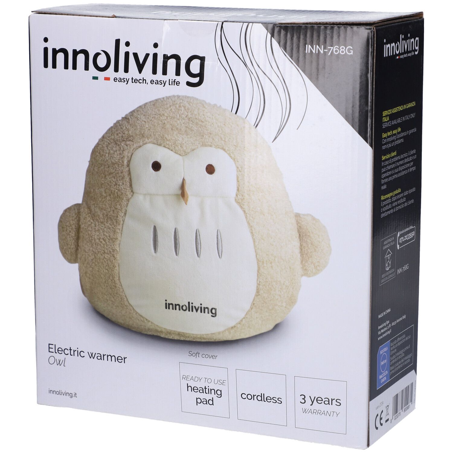 Cuscino termico a forma di gufo beige nella confezione. Marchio: Innoliving. Testo: Electric warmer Owl, ready to use heating pad, cordless, 3 years warranty.