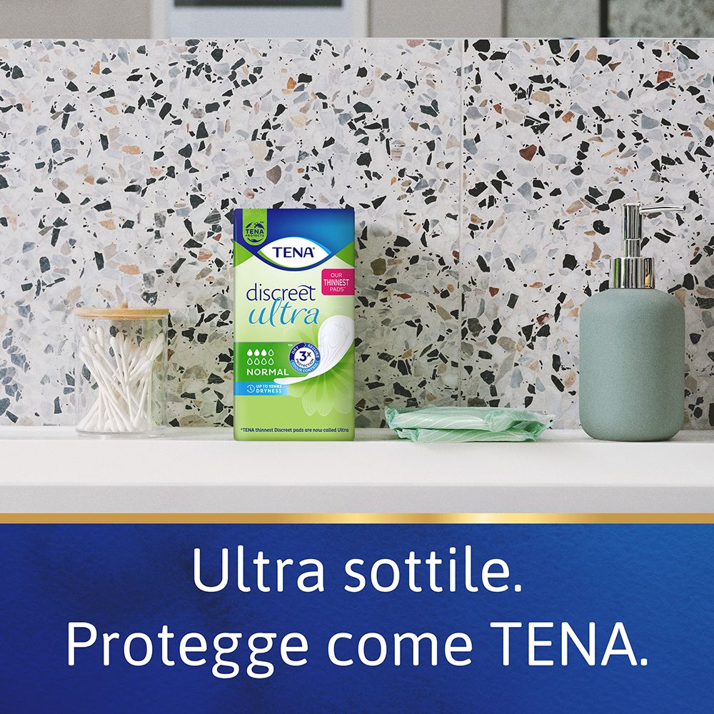 Confezione Tena Discreet Ultra Normal su un ripiano. Sfondo bagno. Altri articoli da bagno.