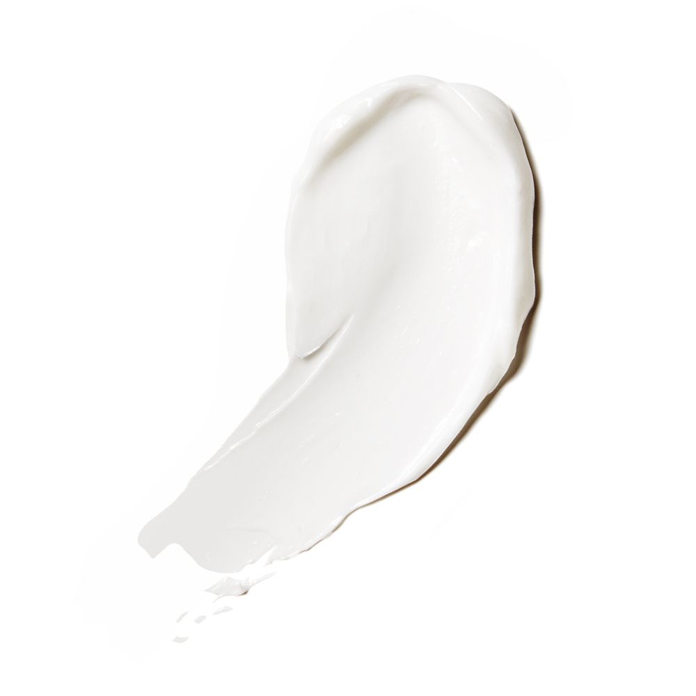 Macchia di crema bianca su sfondo bianco. Consistenza della crema visibile.