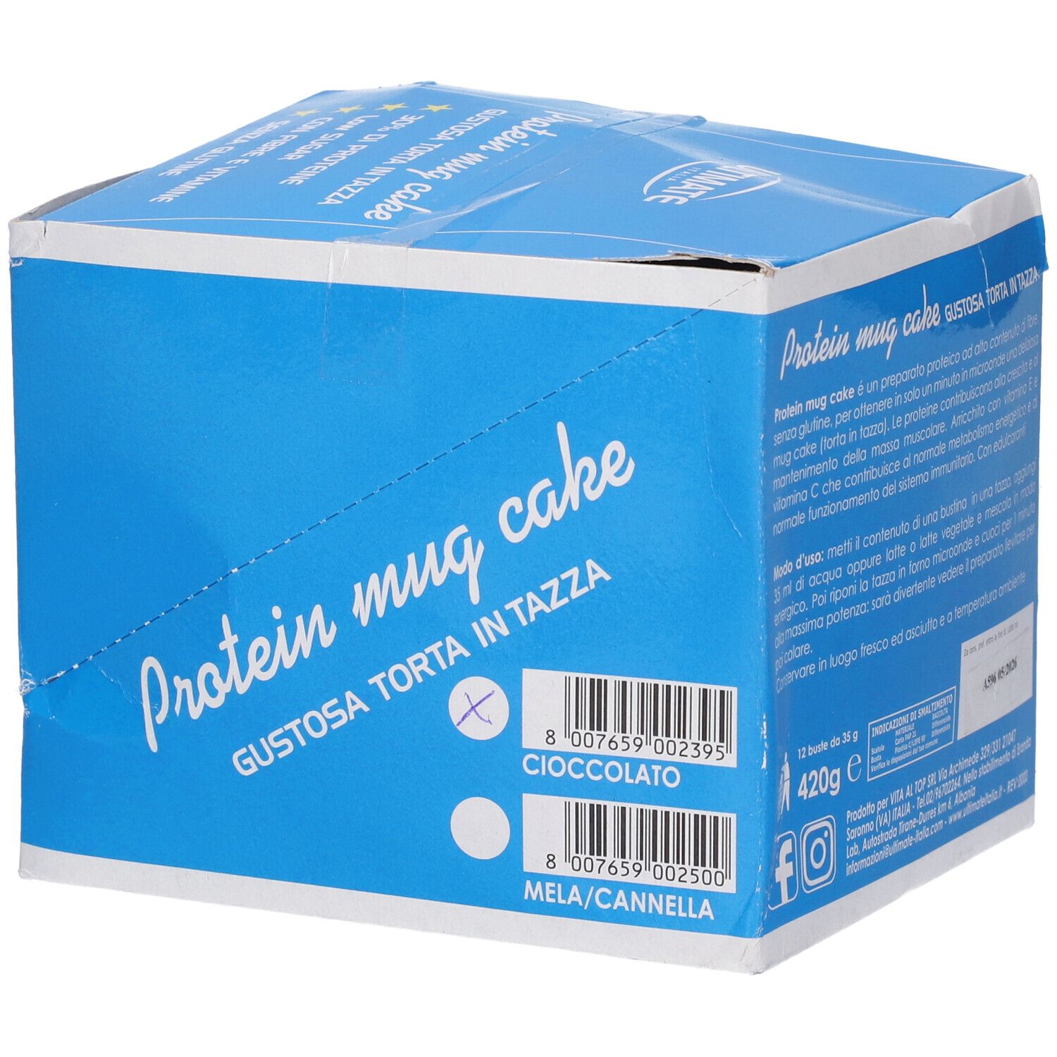 Scatola blu con scritta "Protein mug cake". Contiene informazioni sui gusti: Cioccolato e Mela/Cannella. La scatola è aperta.