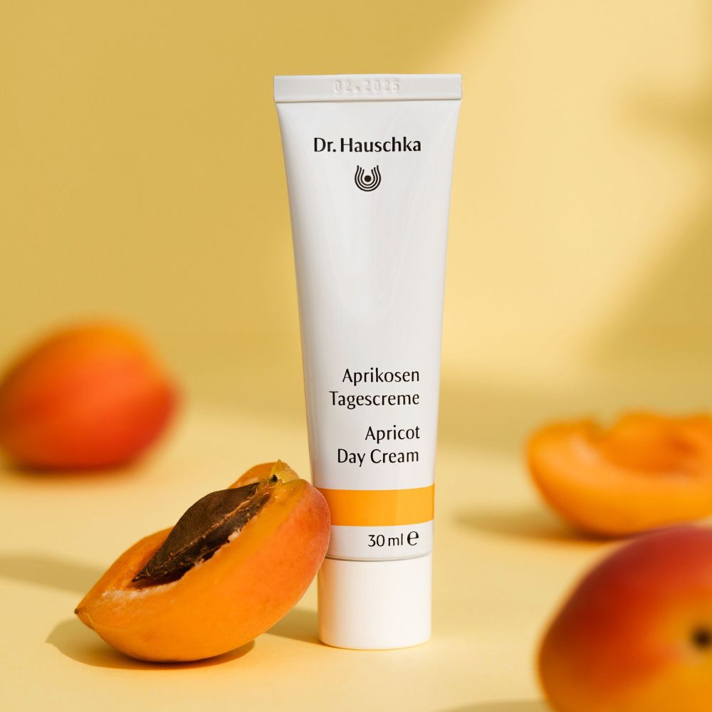 Tubo con scritta: Aprikosen Tagescreme, Apricot Day Cream, 30ml e. Albicocche e metà su sfondo giallo.