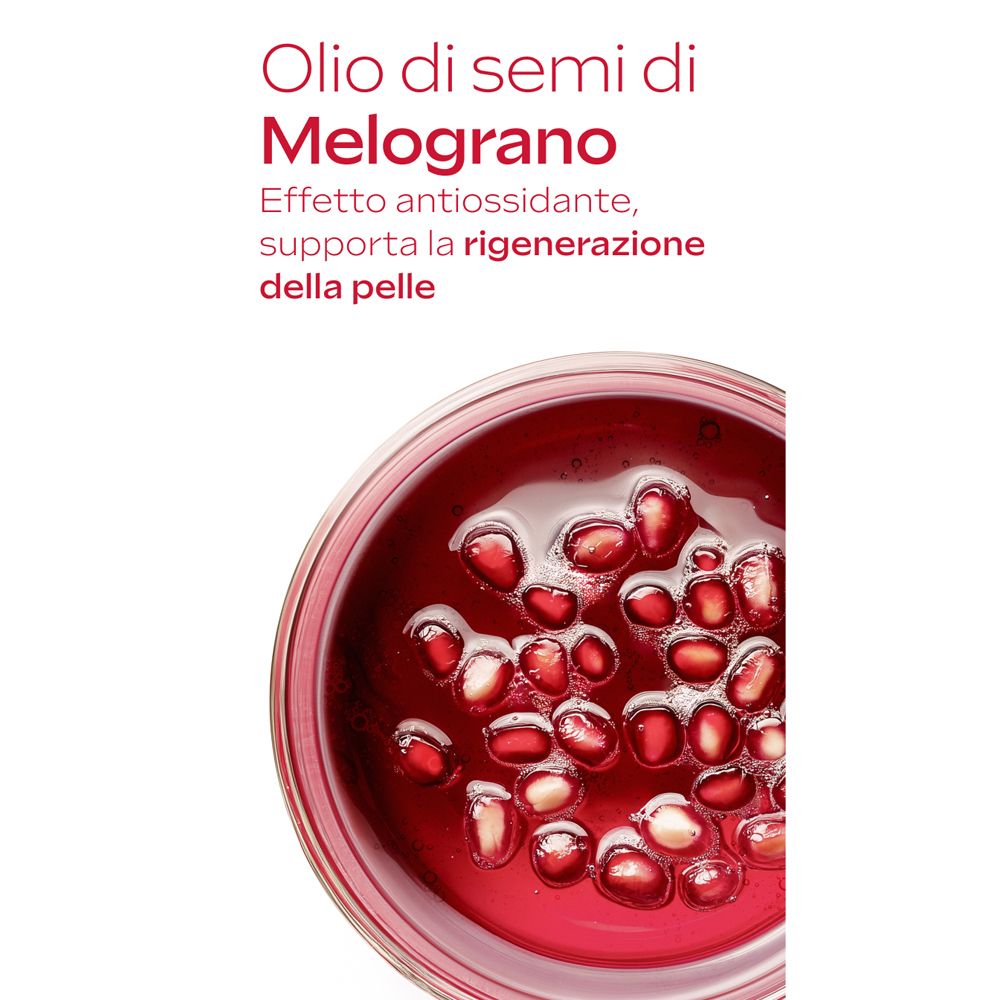 Primo piano di semi di melograno in una ciotola di vetro. Testo: Olio di semi di Melograno. Effetto antiossidante.