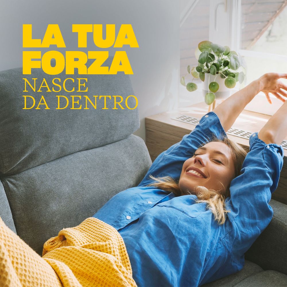 Donna che si stiracchia su un divano, simbolo di vitalità e benessere.