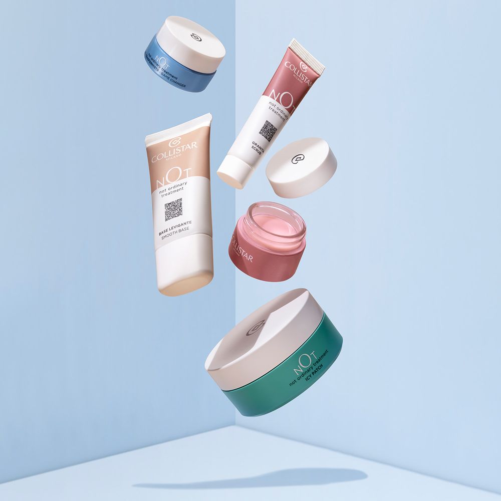 Vari contenitori e tubetti cosmetici fluttuano su uno sfondo azzurro.