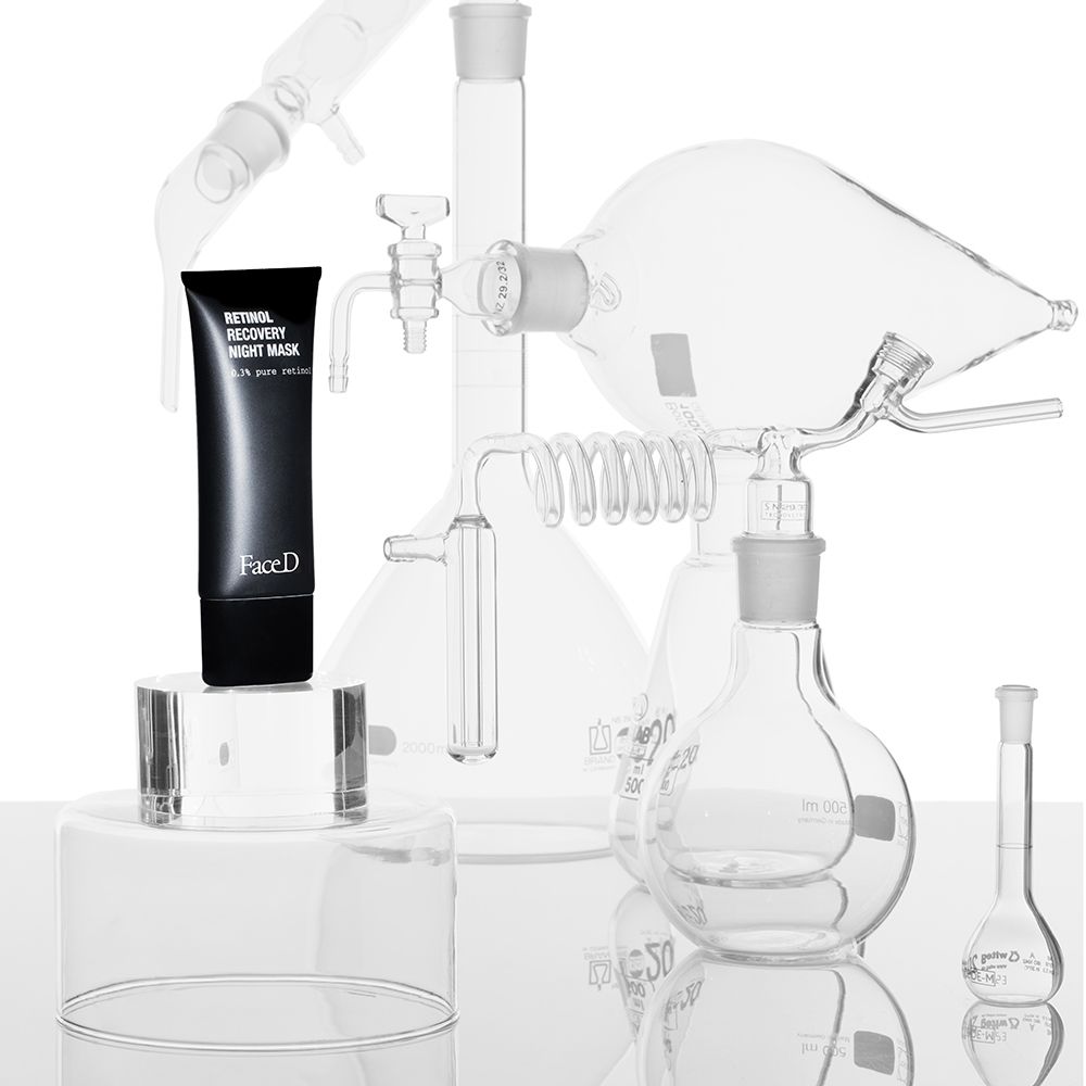 Tubo nero su piedistallo, circondato da vetreria. Scritta: Retinol Recovery Night Mask, FaceD.