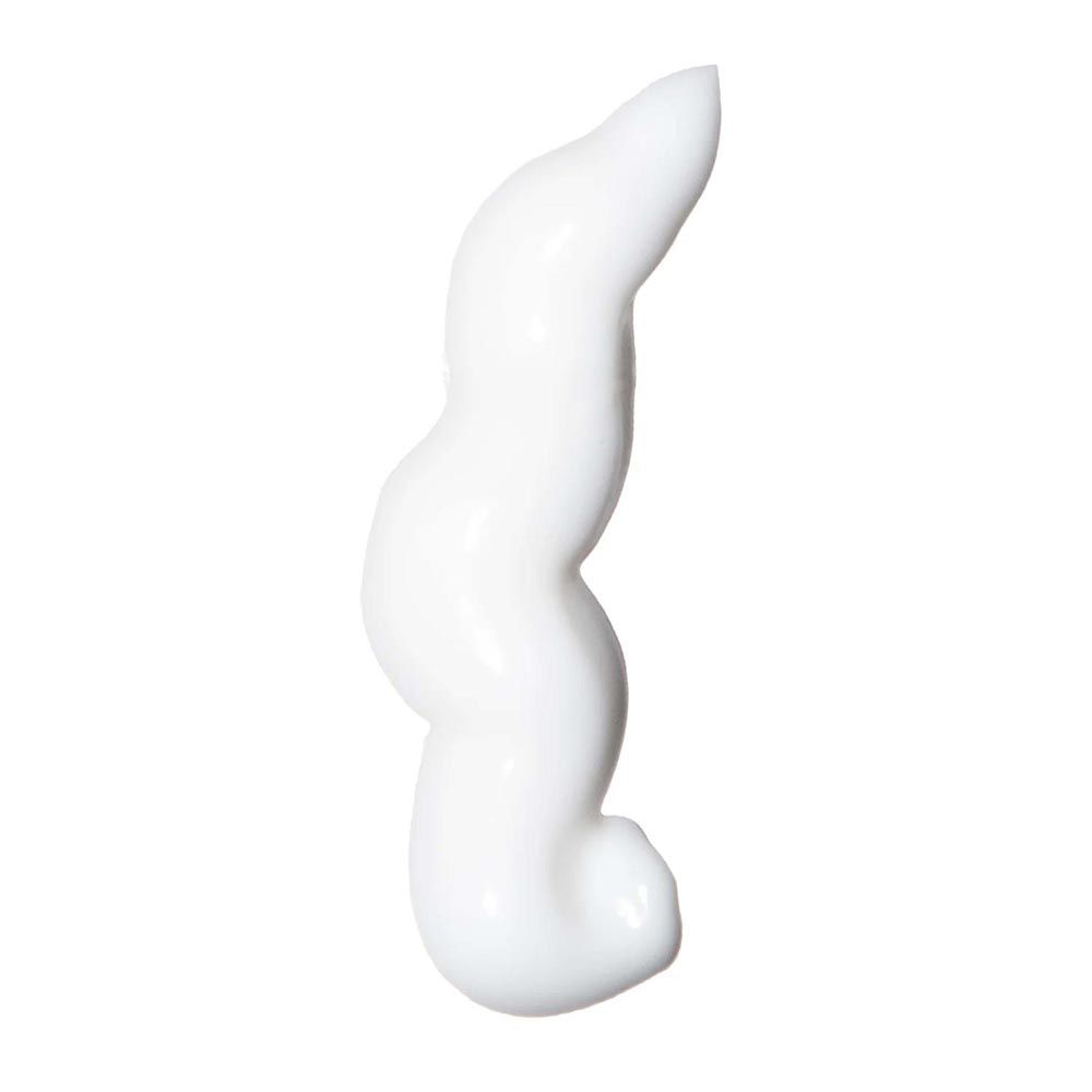 Una striscia di crema bianca di forma curva su sfondo bianco.