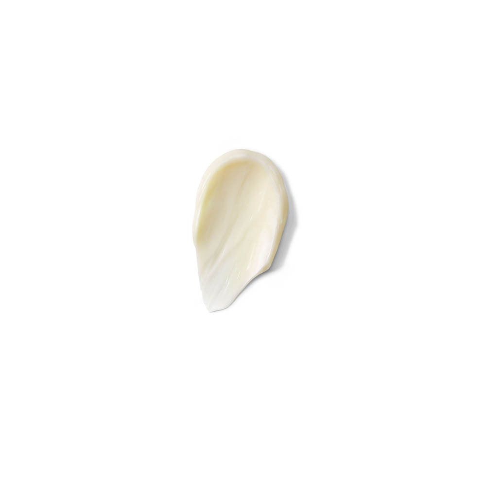 Una goccia di crema color crema su sfondo bianco.