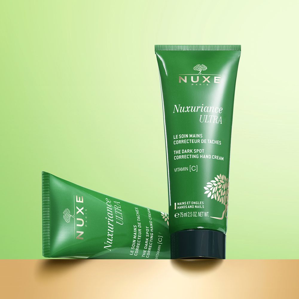 Due tubi verdi Nuxe Nuxuriance Ultra. Testo: Le soin mains correcteur de taches, The dark spot correcting hand cream. Vitamina C.