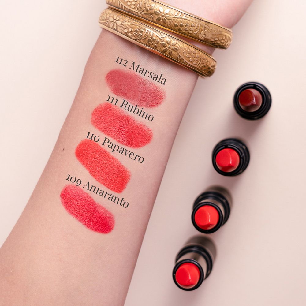 Braccio con campioni di rossetto: 112 Marsala, 111 Rubino, 110 Papavero, 109 Amaranto. 4 rossetti.