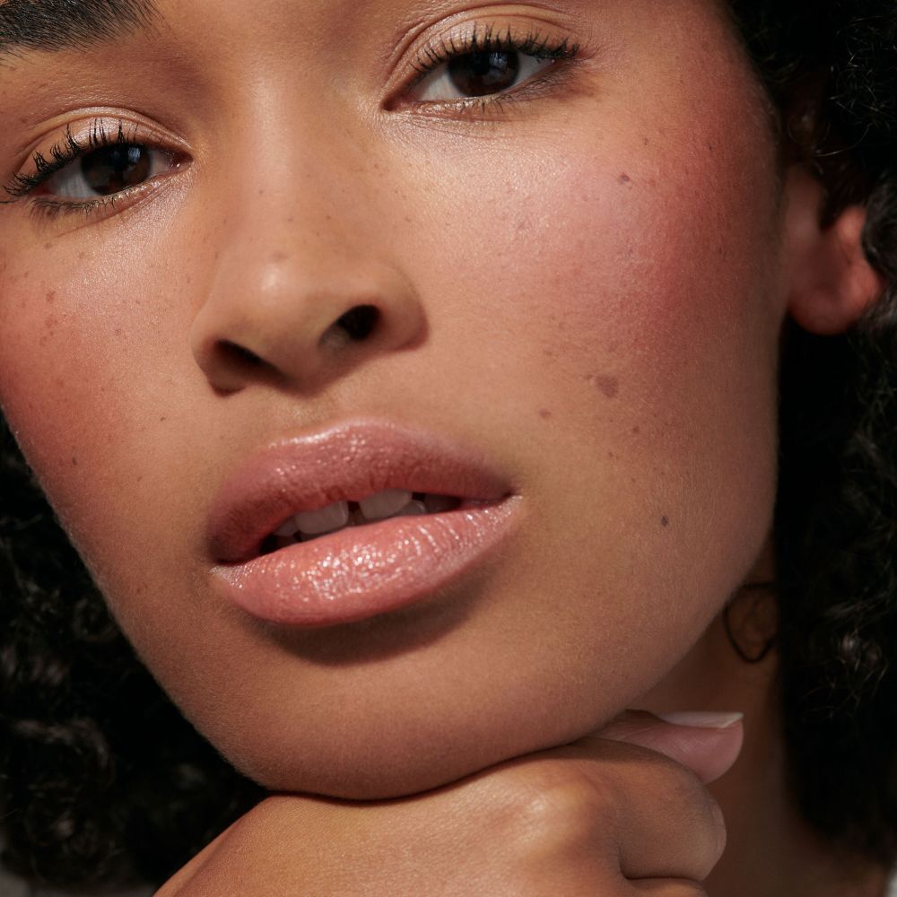 Primo piano di un viso con guance e labbra rosate. Tonalità della pelle.