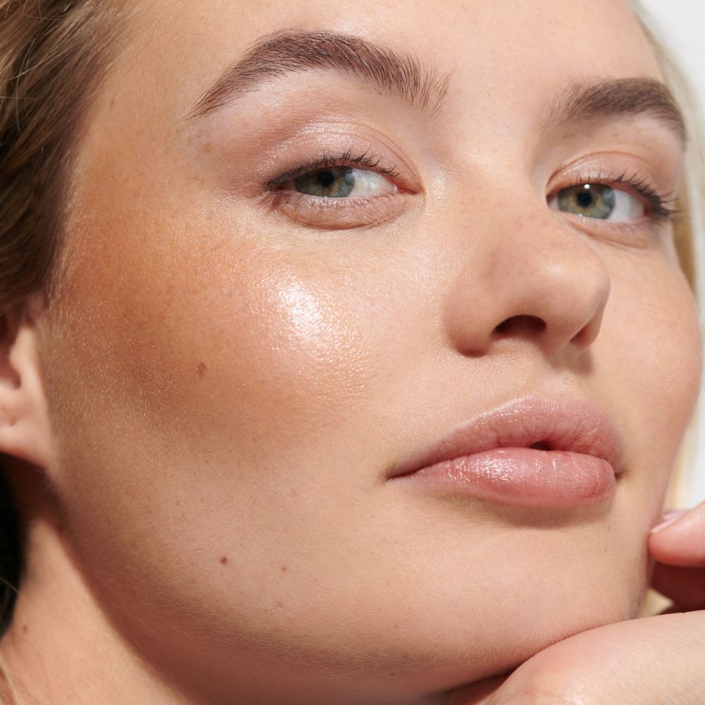 Primo piano di una donna. Stick labbra e guance dorato sulla guancia.