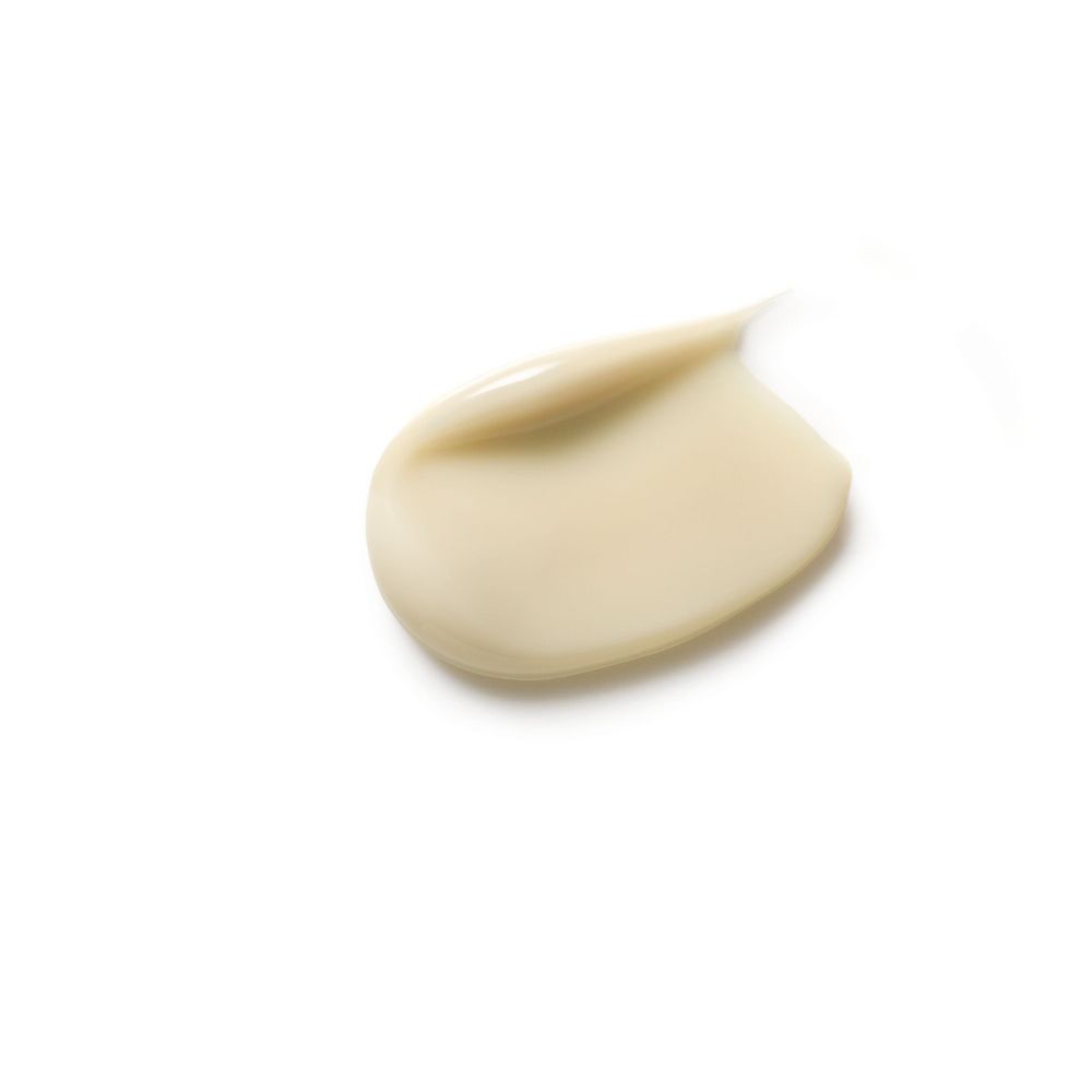 Macchia di sostanza cremosa beige su sfondo bianco.