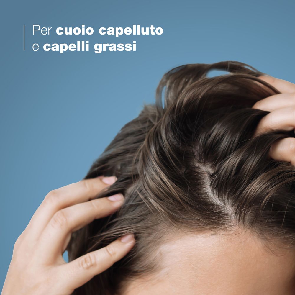 Primo piano di una mano che tocca il cuoio capelluto. Testo: Per cuoio capelluto e capelli grassi.