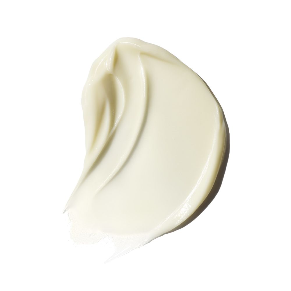 Primo piano di una texture di crema. Traccia ondulata color crema su sfondo bianco.