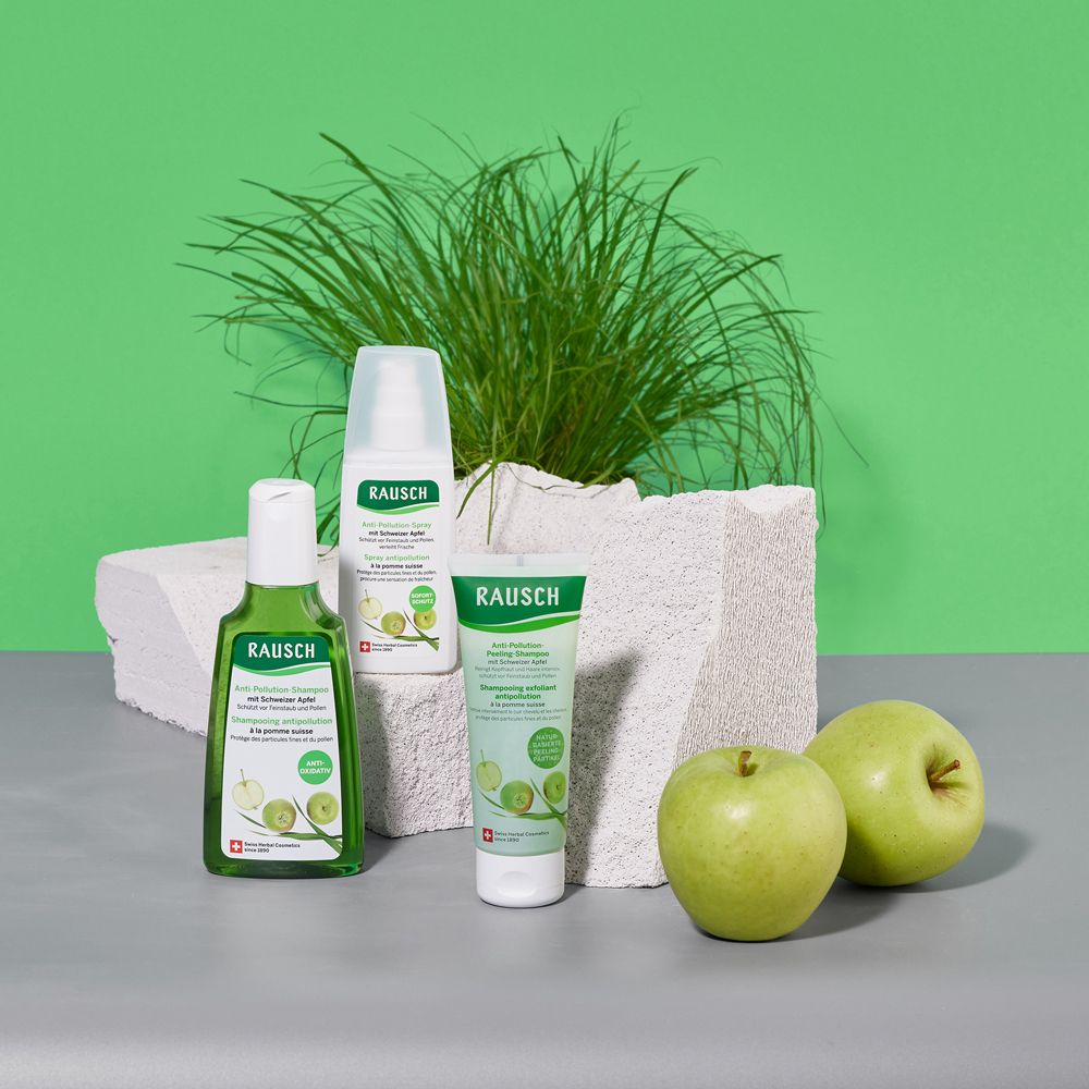 Set di prodotti: shampoo, balsamo e spray. Su blocchi bianchi e sfondo verde. Con mele.