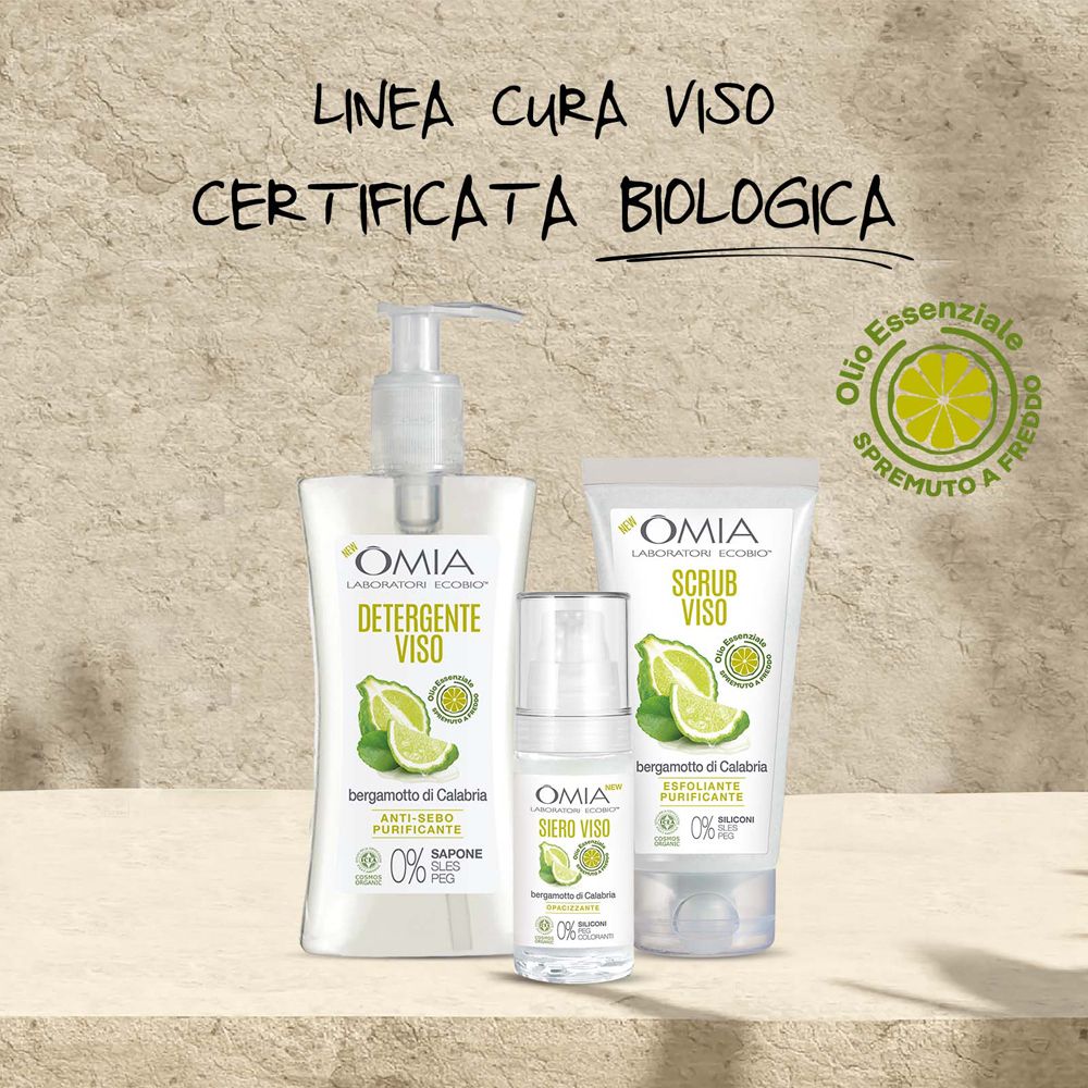 Tre prodotti del marchio OMIA: detergente, siero e tubo di crema. Tutti con bergamotto e scritta.