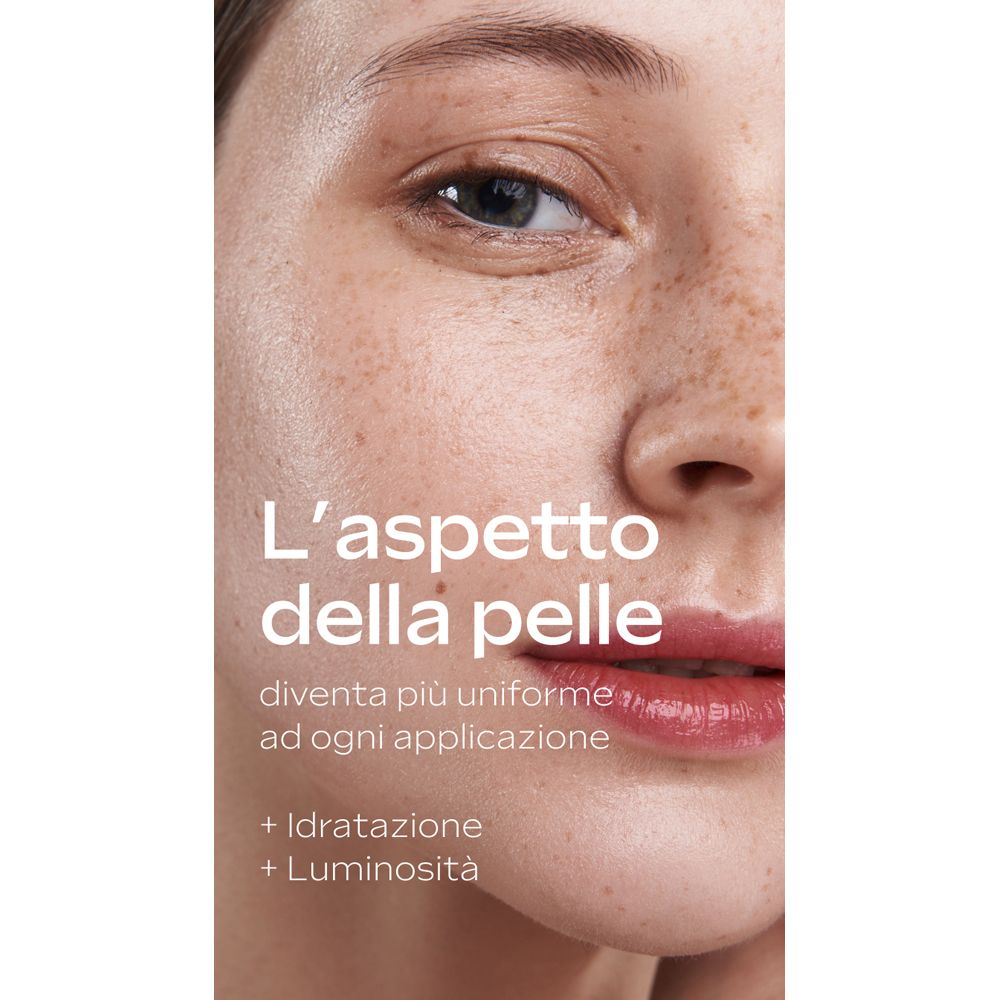 Primo piano di un viso. Testo: L'aspetto della pelle, diventerà più uniforme. + Idratatione + Luminosità.