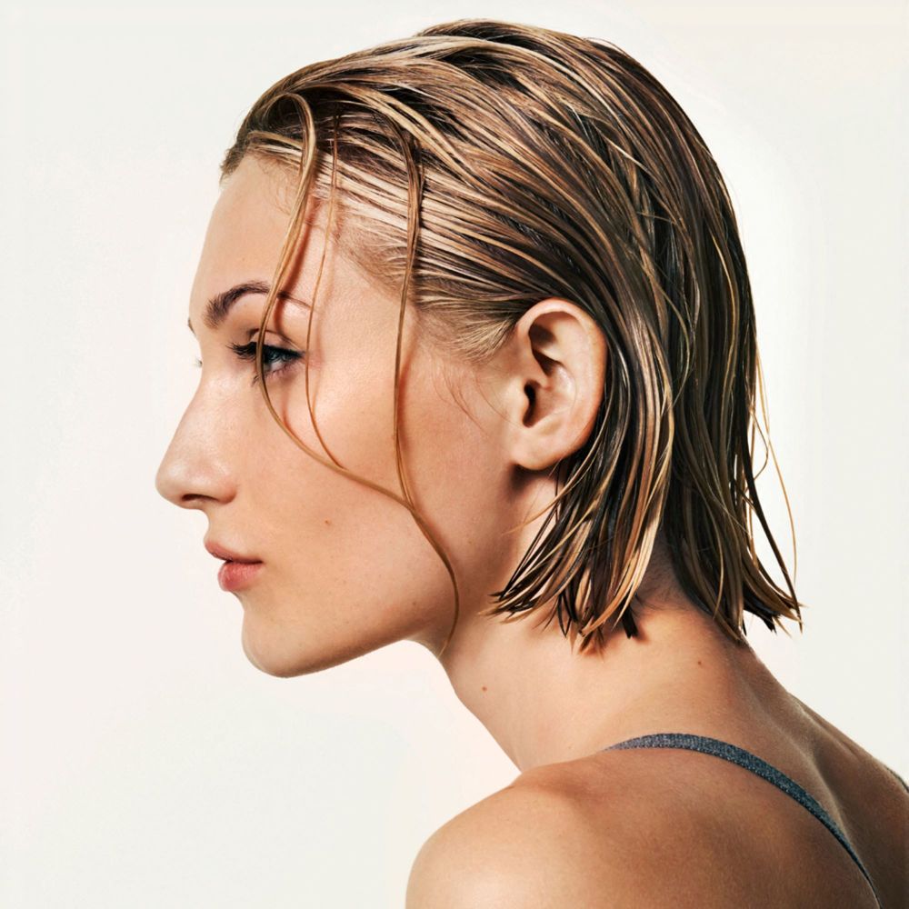Profilo di una donna con capelli bagnati e acconciati.