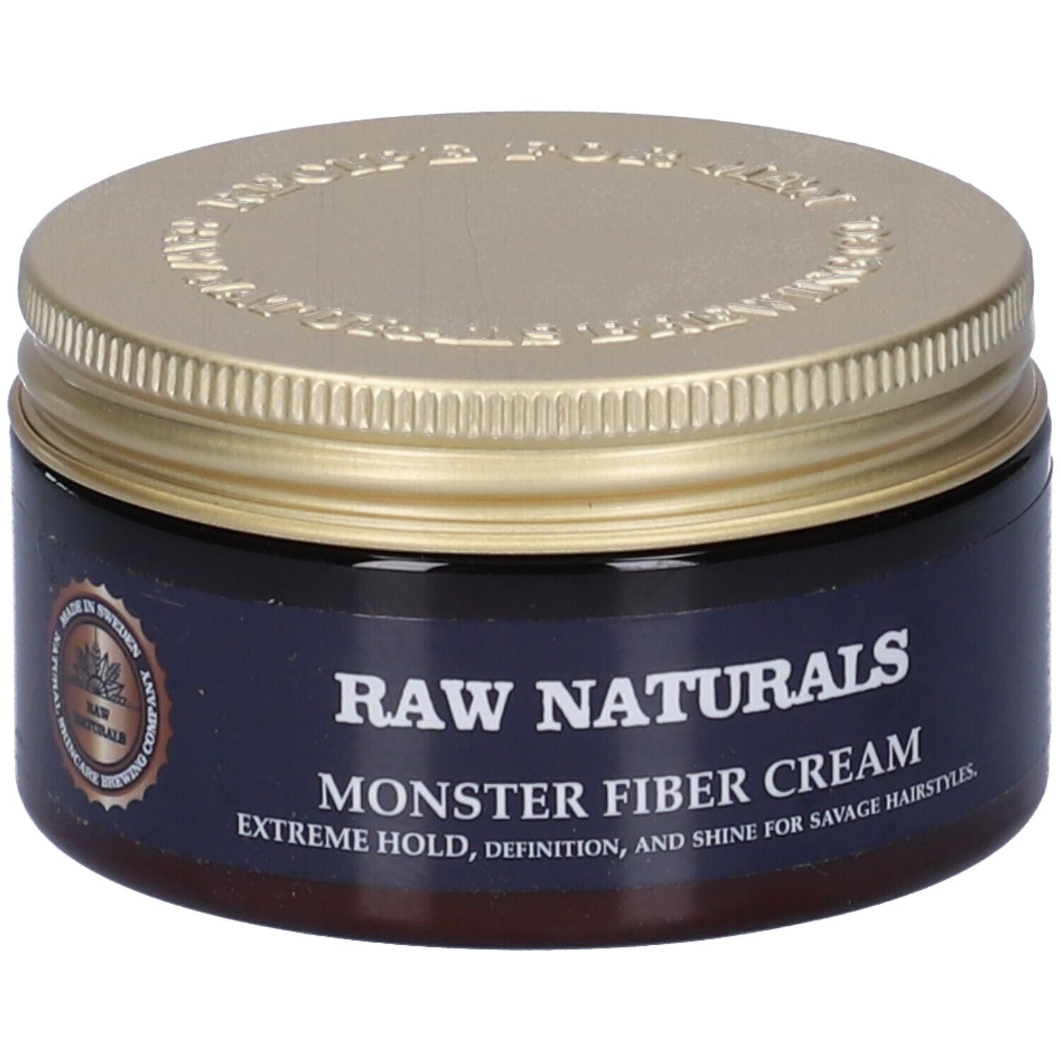 Vasetto marrone scuro con coperchio dorato. Scritta: RAW NATURALS MONSTER FIBER CREAM. Logo: Made in Sweden. Vista del prodotto.