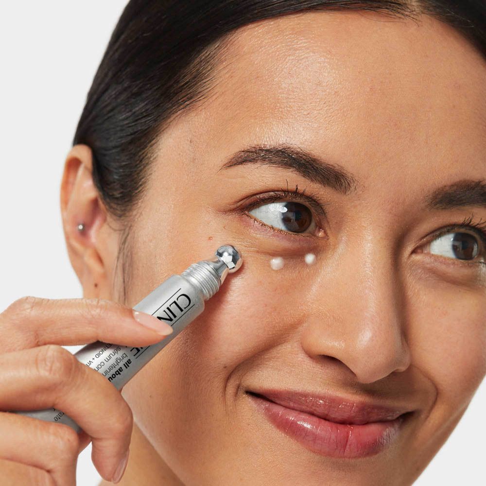 Donna applica crema contorno occhi con applicatore.